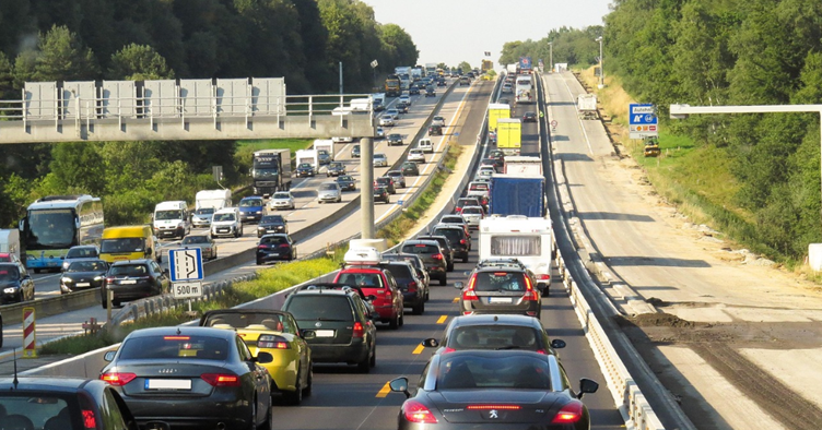Verkeersdrukte op een snelweg met files in beide richtingen en wegwerkzaamheden langs de rijbaan.