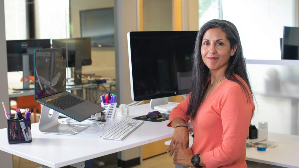 Vrouw aan bureau met computer in kantooromgeving, passend bij een praktisch CFO profiel in actie