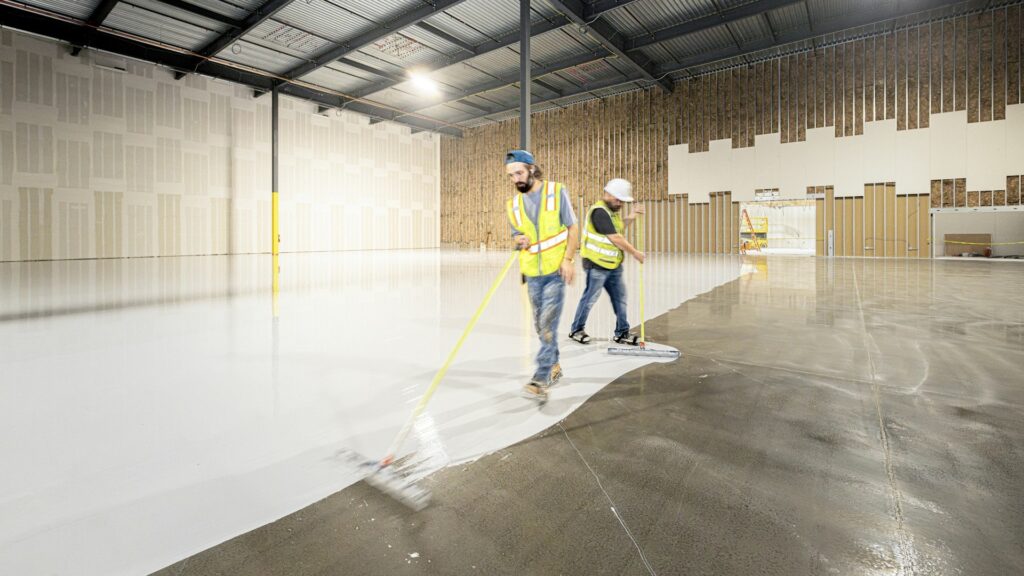 Zwaarlastvloer wordt aangebracht op betonvloer in hal, met egaliseren voor stabiele en belastbare ondergrond