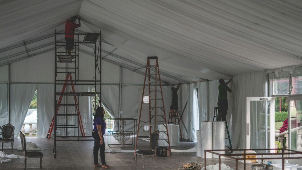 Zwaarlastvloer in tent tijdens opbouw met ladders en personeel, voorbereiding op intensief gebruik en belasting